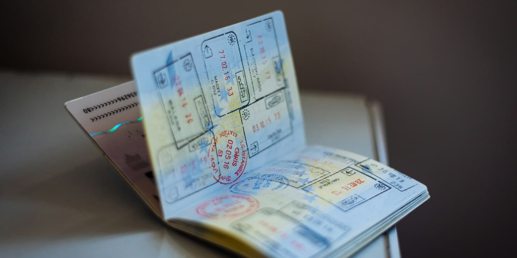 An open passport with visa stamps on a table